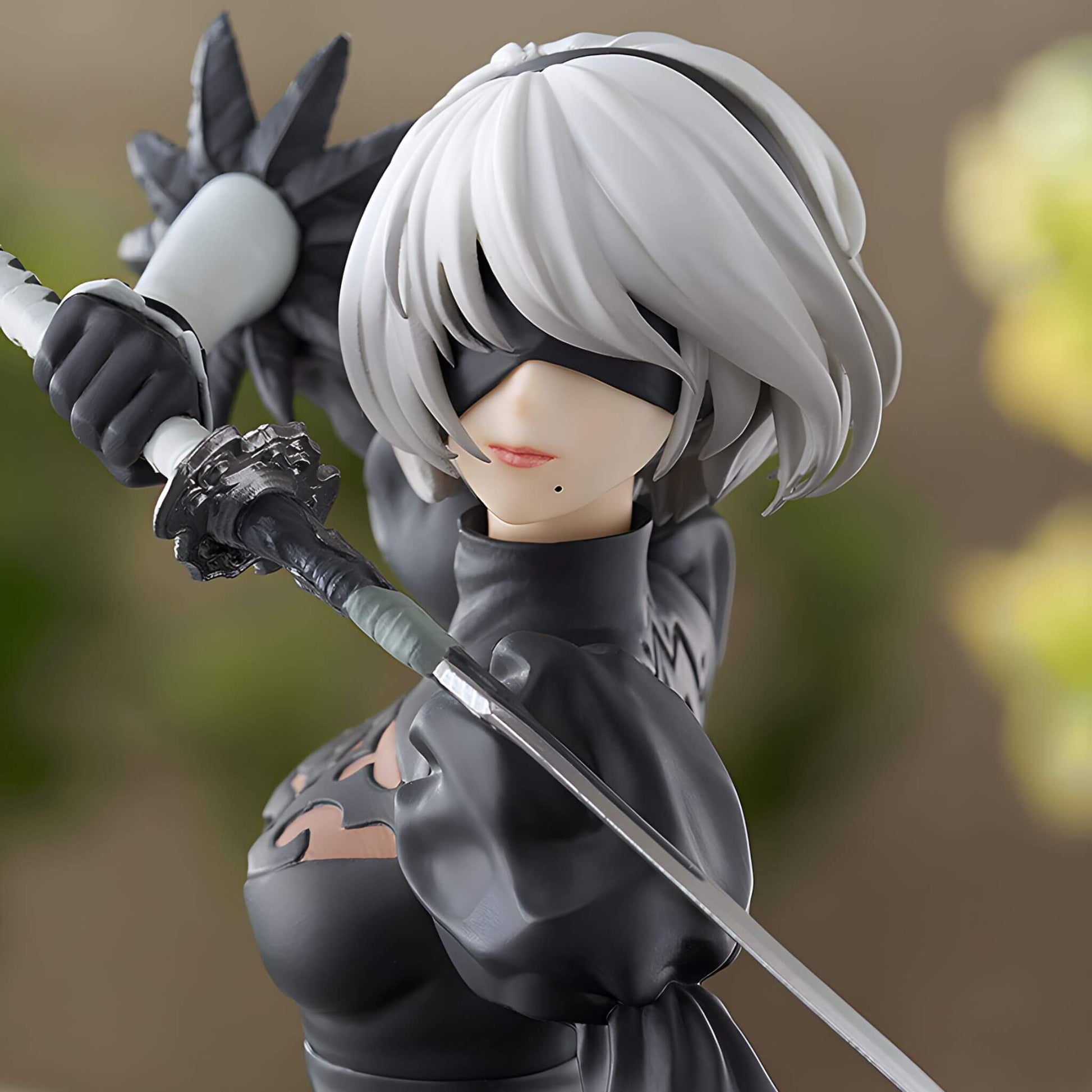 Close look of Good Smile Company NieR Automata Pop Up Parade 2B (YoRHa No.2 Type B) Figure with eyecover, white hair and a sword, wearing black clothing.