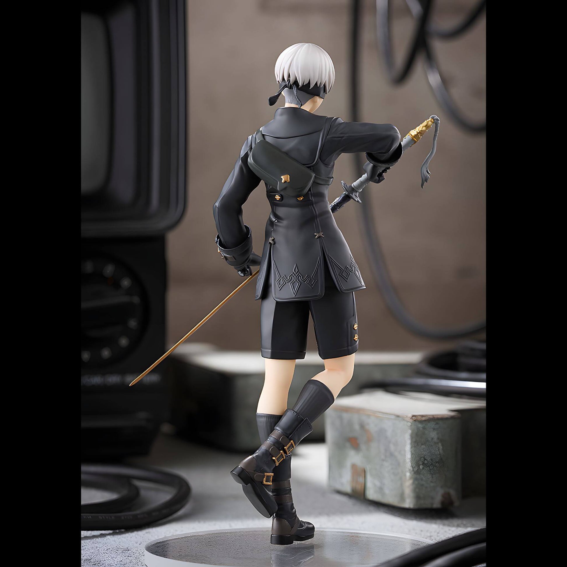 Good Smile Company NieR Automata Pop Up Parade 9S (YoRHa No.9 Type S) Figure in dark attire with a sword, standing on a textured surface.