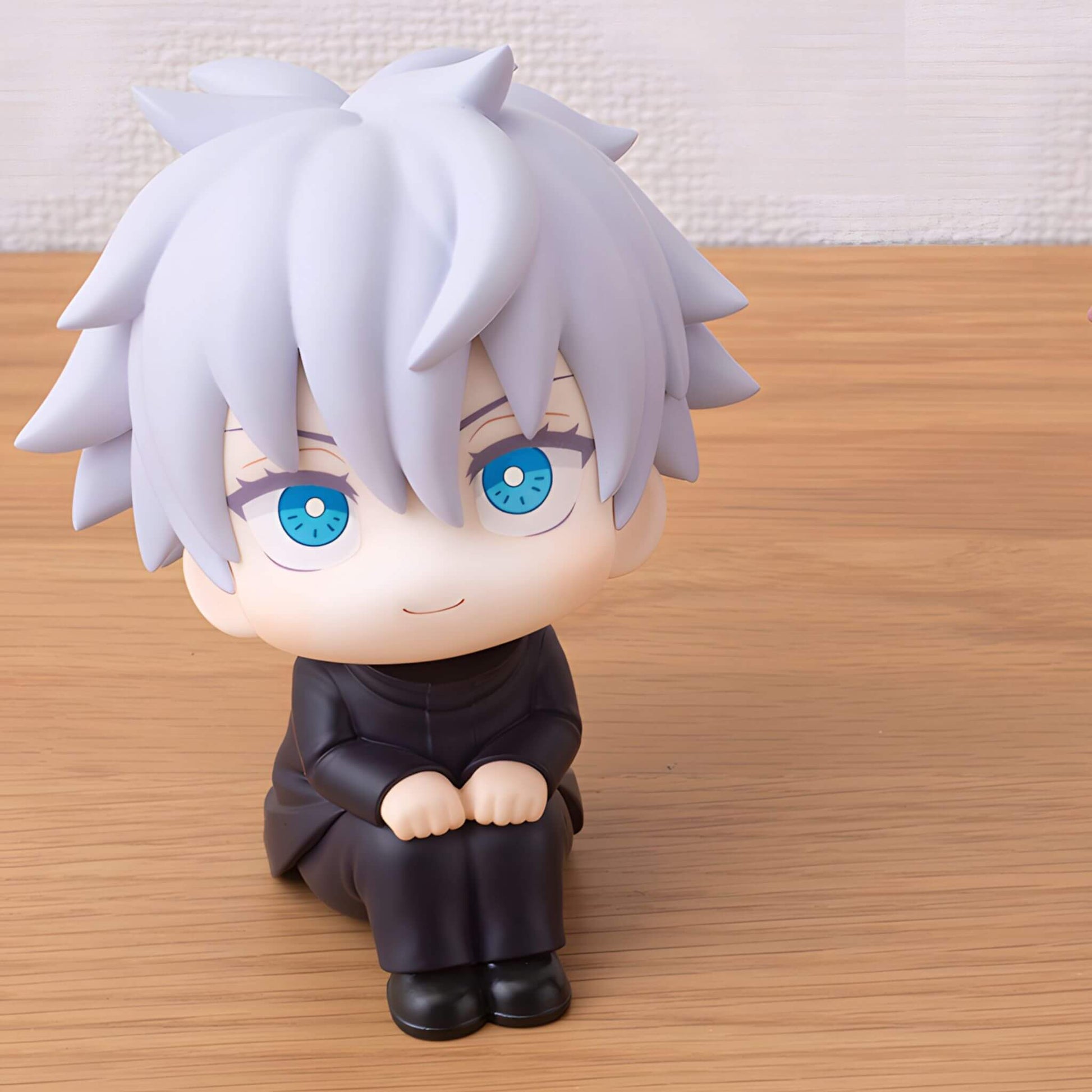 Megahouse Jujutsu Kaisen Look Up Series Satoru Gojo figurine with white hair and blue eyes sitting on a wooden surface