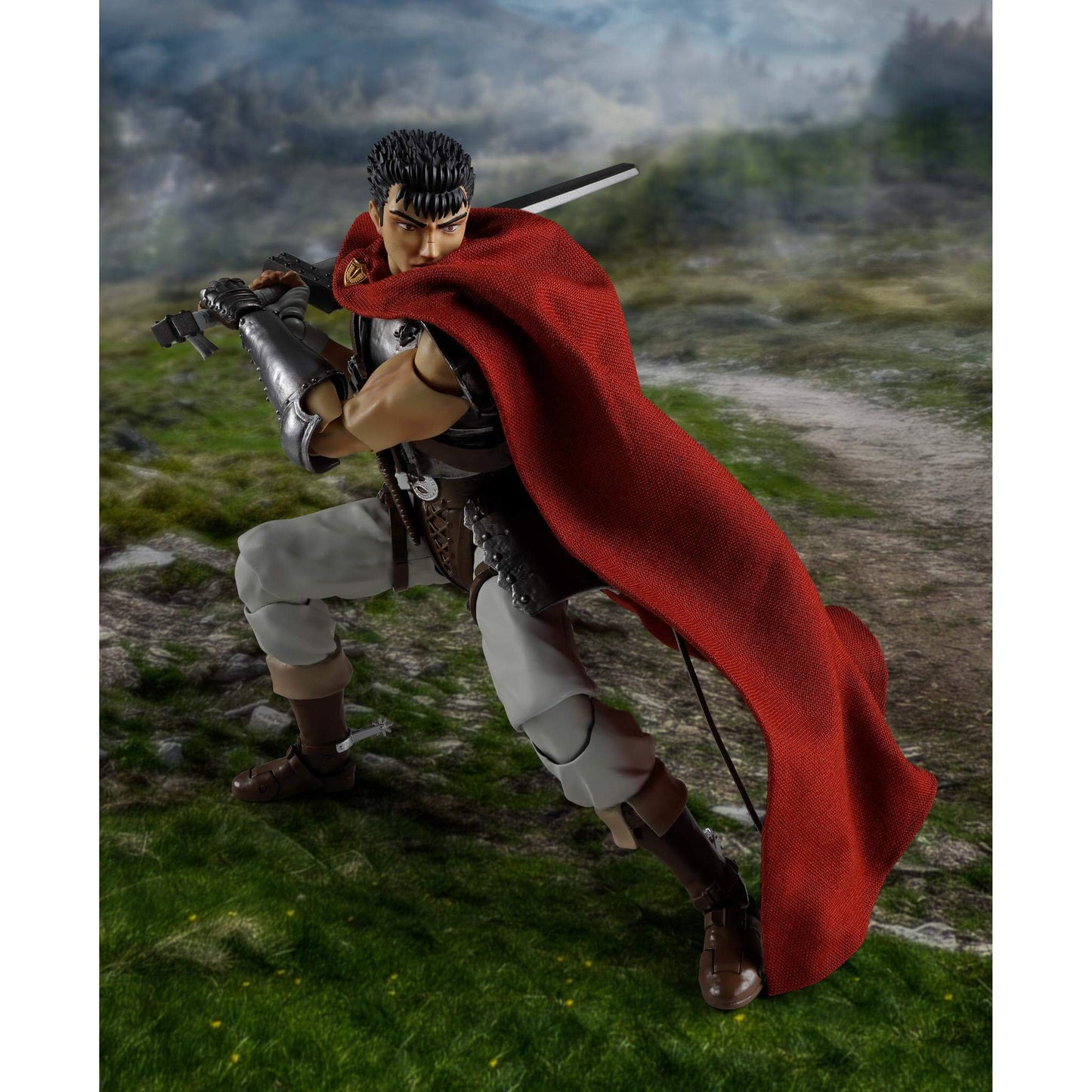 Berserk S.H.Figuarts Action figure of Guts with a red cape and sword in a grassy outdoor setting