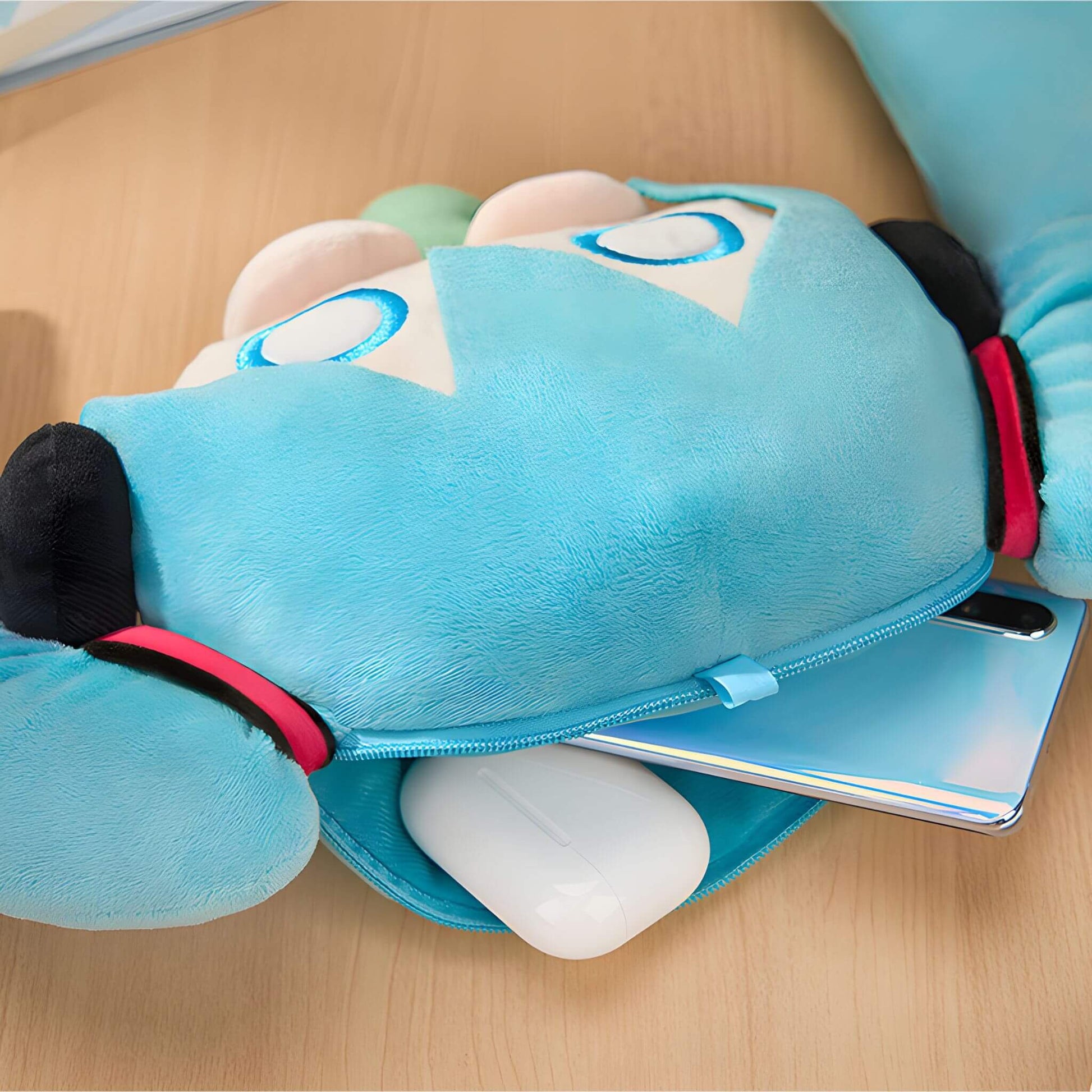 Hatsune Miku Plushie Pouch with a white paw on a wooden surface