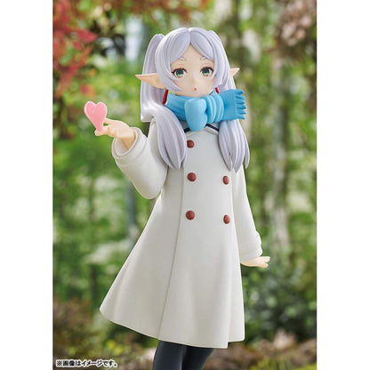 Frieren Blow Kiss Pop Up Parade figure   with white hair and blue scarf holding a pink heart, standing outdoors.