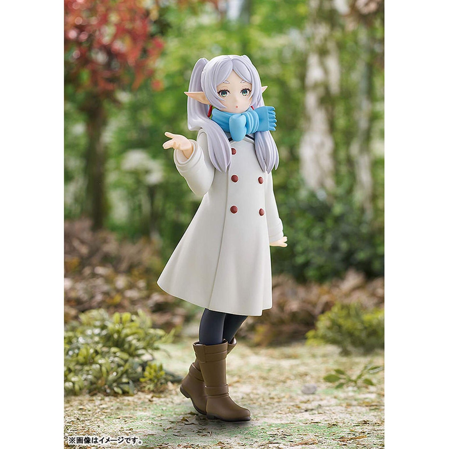 Frieren Blow Kiss Pop Up Parade figure in a white coat with red buttons and blue scarf standing outdoors.