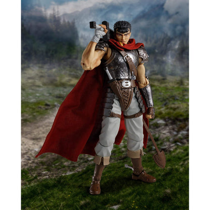 Berserk S.H.Figuarts Action figure of Guts in warrior costume with red cape and armor standing in a natural landscape