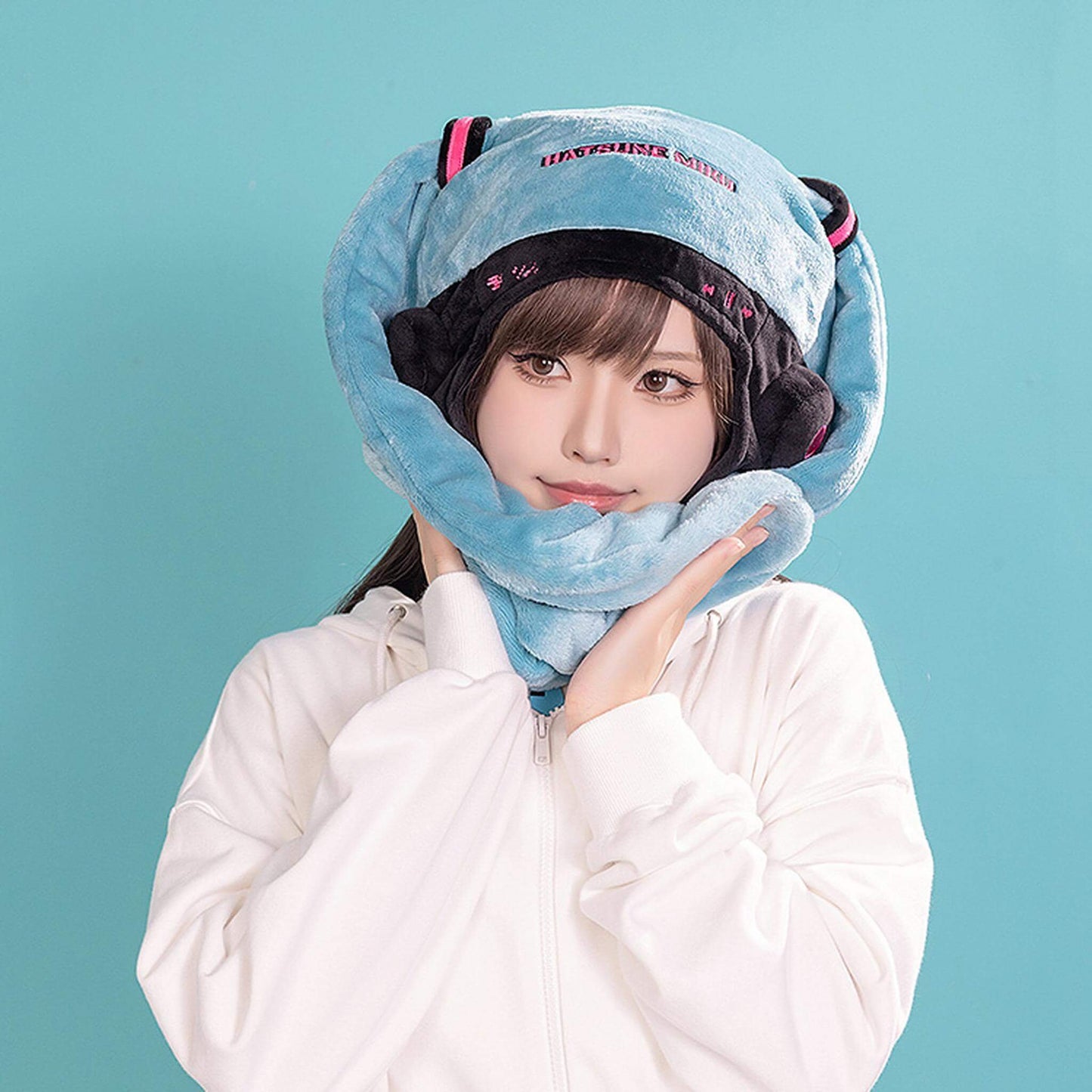 Person wearing a Hatsune Miku Character Hat against a teal background