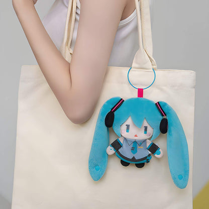 Hatsune Miku Keychain Pouch of a character with blue hair and headphones attached to a beige tote bag.