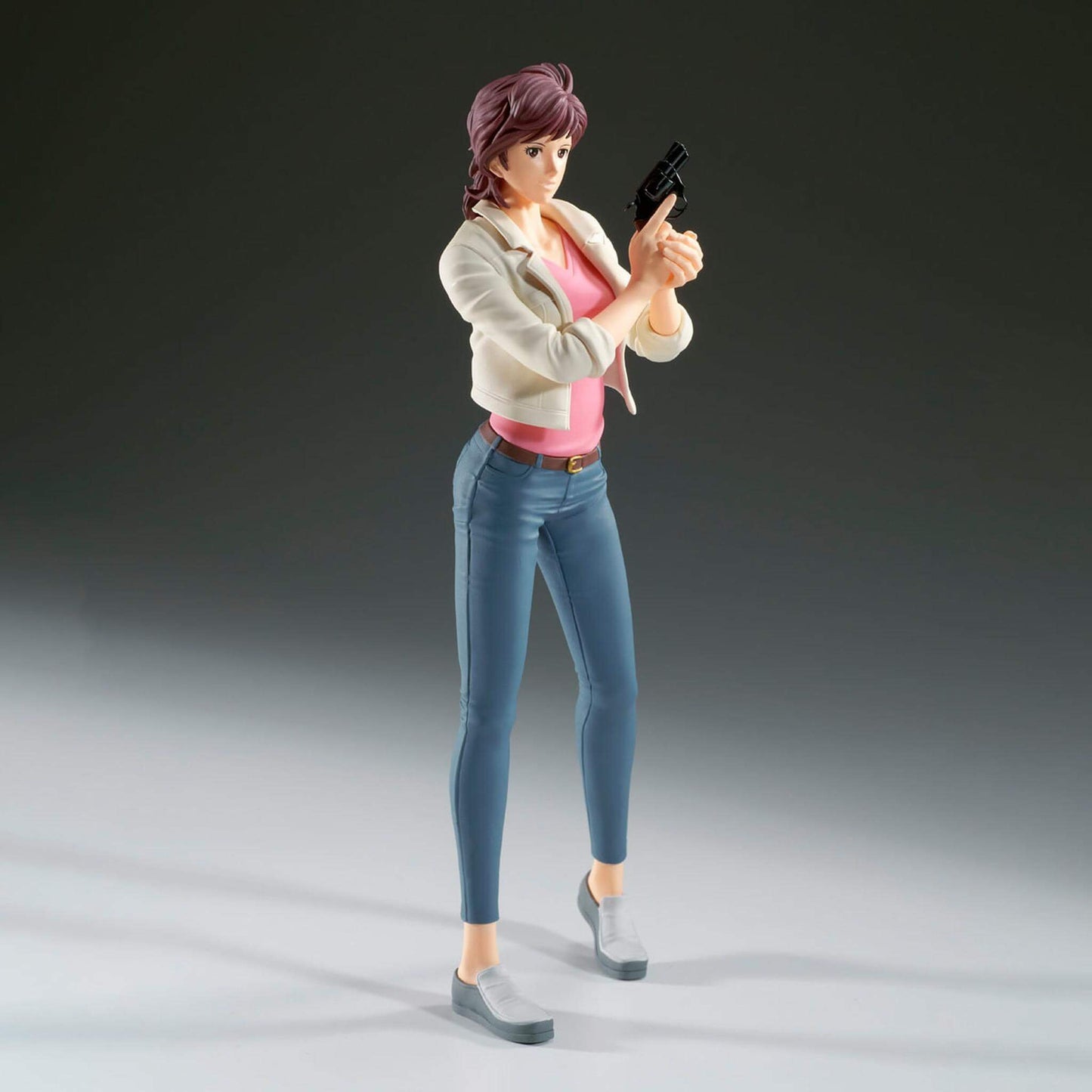 Side view of City Hunter anime figure of Kaori Makimura holding a gun on a gray background with depth